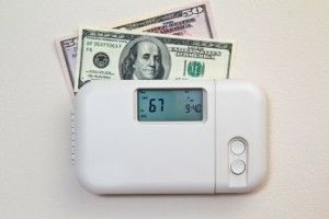 100 dollar bills sticking out of a thermostat