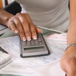Woman doing a cost breakdown on a calculator