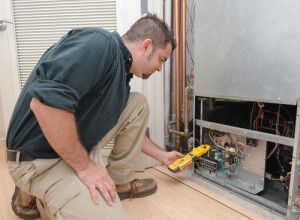 Tech performing maintenance on heat pump