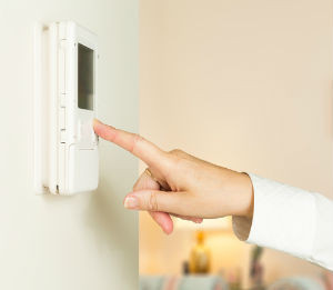 Woman adjusting a thermostat